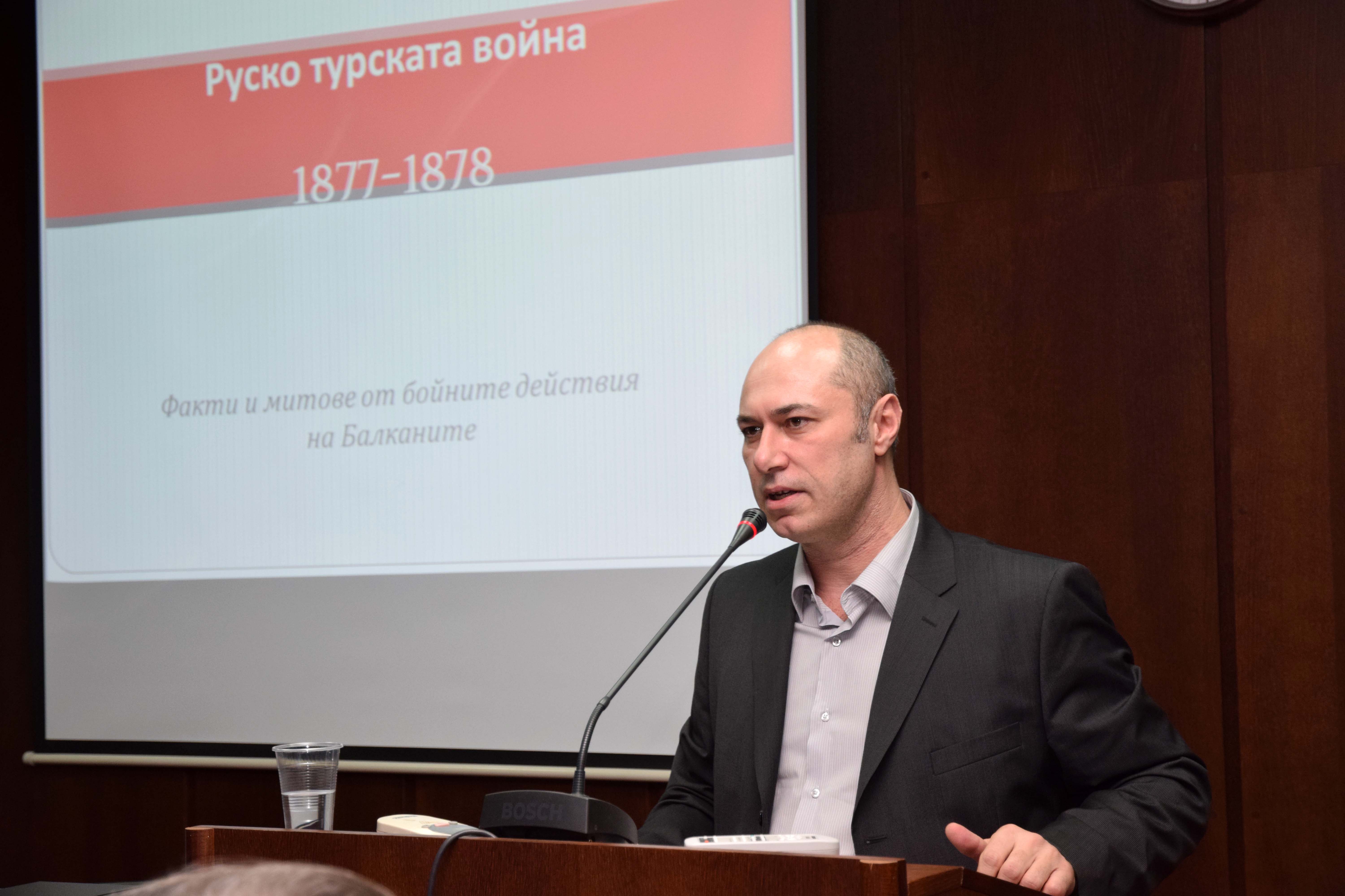 Лекторът гл.ас. д-р Румен Андреев от катедра „Политическа икономия“ <em>(на снимката долу</em>) запозна аудиторията с някои по-малко известни факти от Руско-турската война, като се спря подробно на плана на руското командване, разработен от генерал Николай Обручев, бойните действия на Балканите, битката при Плевен, боевете на връх Шипка. Той илюстрира събитията с архивни снимки и фотоси на картини, както и с графика, показваща състава на българските и руските опълченци, участвали в Шипченската битка.